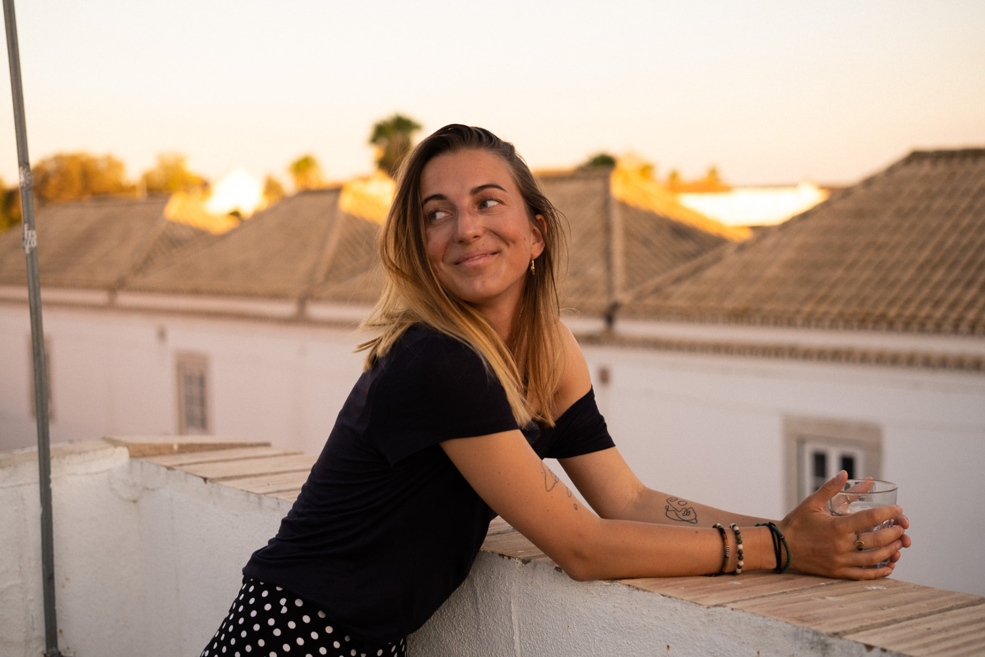 Tinsley leaning on a rooftop wall at golden hour